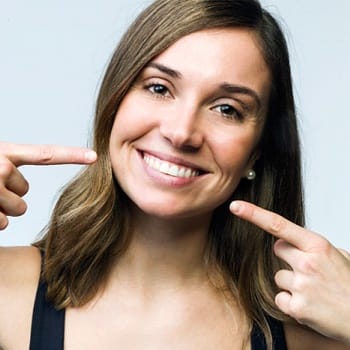 Woman Pointing to teeth - Dental Bonding Dallas TX