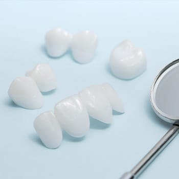 Cosmetic Dentistry Porcelain Teeth sitting near dental mirror