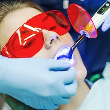 Woman having teeth whitened at Cosmetic Dentist - Dallas, TX