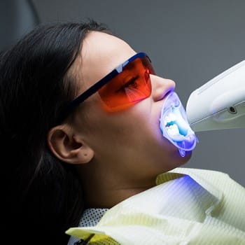 Woman having teeth whitened at Cosmetic Dentist - Dallas, TX