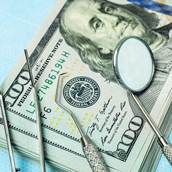Dental tools resting on top of money