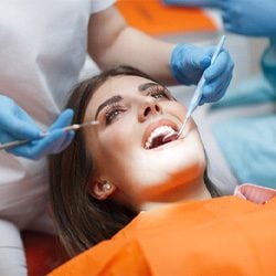 Smiling Woman having teeth Inspected during a cosmetic Dentistry Consult