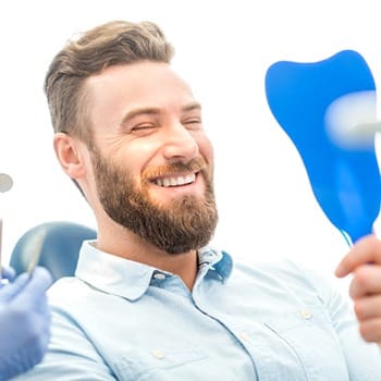 Man smiling in mirror with Cosmetic Dentistry Dentist - Dallas, TX
