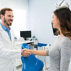 Woman shaking hands with dentist - Emergency Dentistry in Dallas, TX