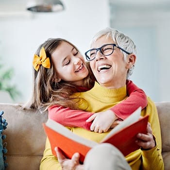 Womansmiling and reading with granddaughter