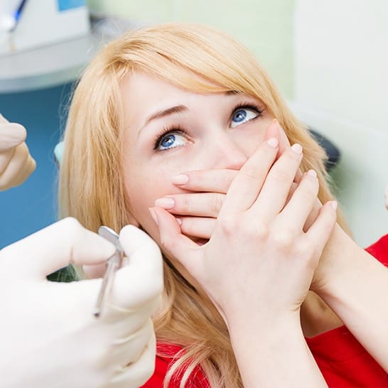 Woman covering mouth at the dentist