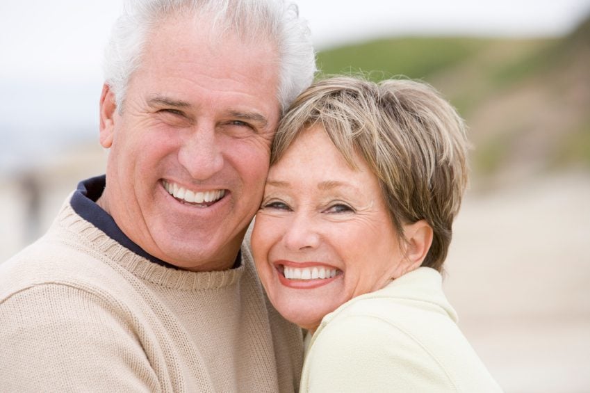 An elderly couple in Dallas smiling after restorative dental treatments.